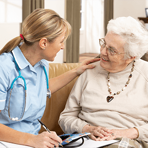 Nursing Healthcare - Nurse Speaks with Smiling Elderly Woman